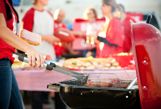 Tailgating: Woman Grilling Bratwurst for Party