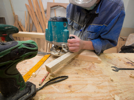 man using router on plank of wood